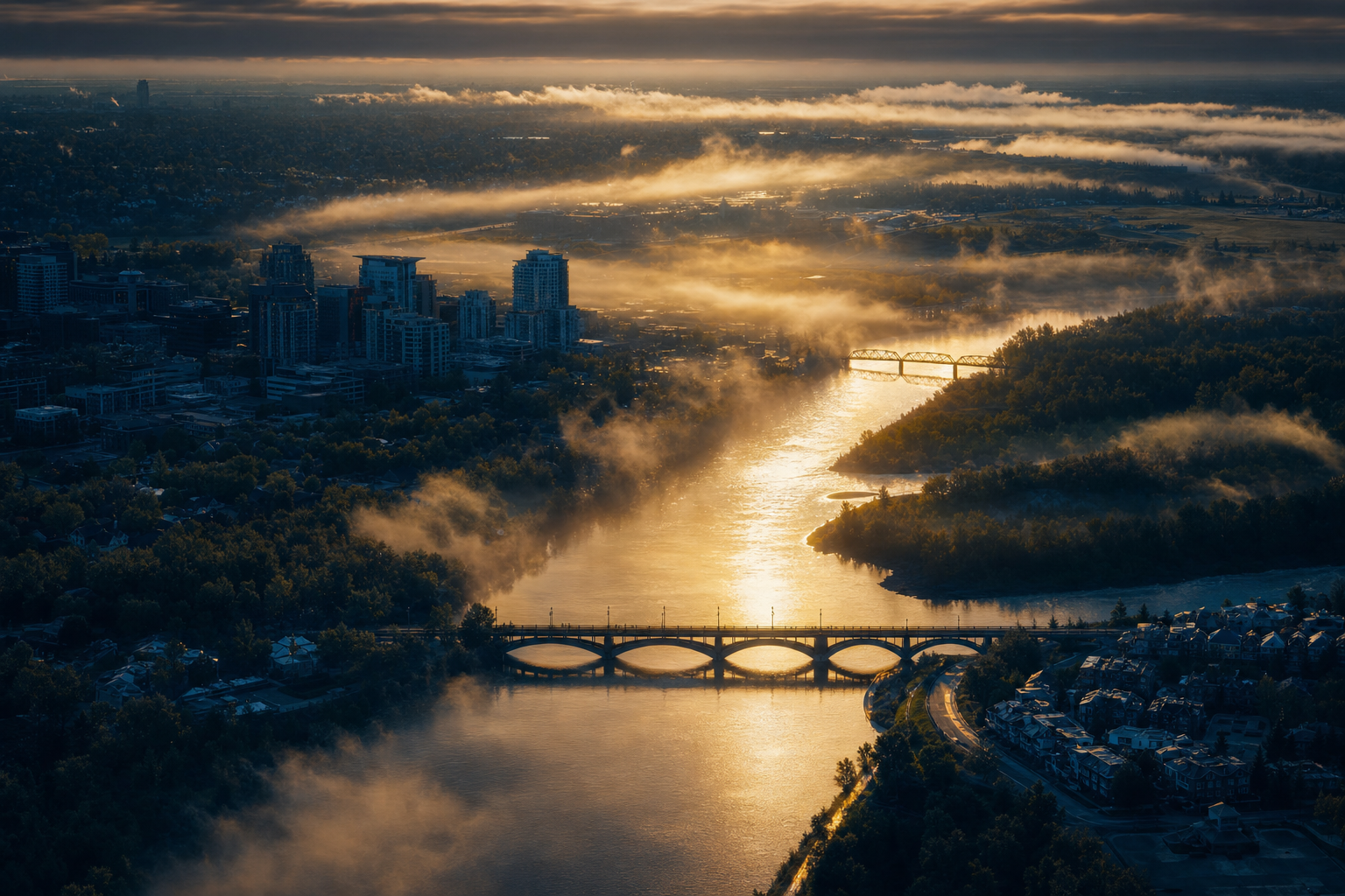 Bow River winding through Calgary at dawn under golden mist